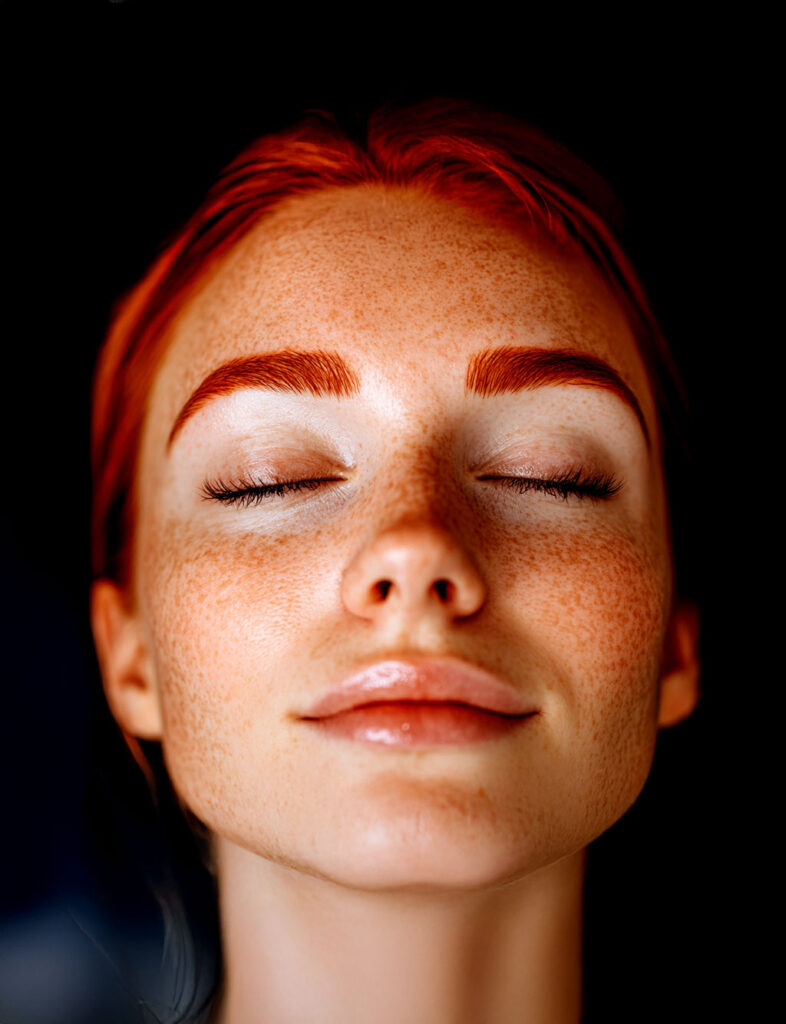 Red-haired woman receiving professional brow tinting treatment during Lash & Brow Girl Academy Brow Tinting Certification course